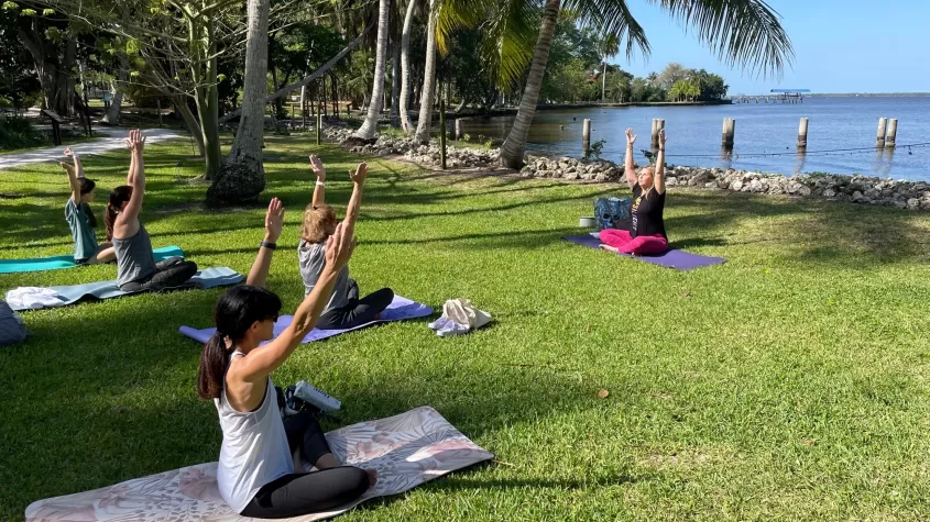 Visitors participate in a yoga class by the Caloosahatchee River. 